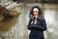 Young adorable woman wearing blue hooded coat enjoying strolling in winter forest outdoors. Nature cold season freshness concept. Royalty Free Stock Photo