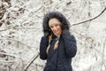 Young adorable woman wearing blue hooded coat enjoying strolling in winter forest outdoors. Nature cold season freshness concept. Royalty Free Stock Photo