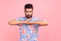 Young adult aggressive bearded man standing keeping fists together, being ready to fight, expressing