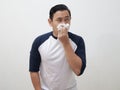 Young adult Asia man sneezing covering his nose with tissue paper,person suffer from cold or fever, health issue