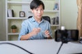 Young adult Asian beauty video blogger man filming, online live streaming his video blog about male cosmetic, male skincare. Guy