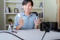 Young adult Asian beauty video blogger man filming, online live streaming his video blog about male cosmetic, male skincare. Guy