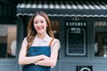 Young adult Asian business woman crossing her arms in front of cafe restaurant while smiling. Happy barista of Coffee Royalty Free Stock Photo