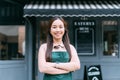 Young adult Asian business woman crossing her arms in front of cafe restaurant while smiling. Happy barista of Coffee Royalty Free Stock Photo