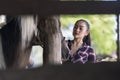 Young adult Asian woman fashion in natural environment. woman enjoying riding a horse in countryside. Cheerful cute model in Royalty Free Stock Photo