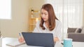 Young adult Asian woman work at home or modern office, using notebook laptop computer. Work from home life, information technology Royalty Free Stock Photo