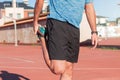 Young adult athlete man doing warm-up exercises and stretching the muscles of his legs, quadriceps and calves to avoid serious