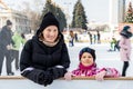 Young adult attractive beautiful caucasian woman enjoy having fun with little kid girl at outdoor skating rink while Royalty Free Stock Photo