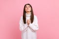 Young adult attractive brunette girl looking up with hands in prayer, sincere saying please, apology Royalty Free Stock Photo