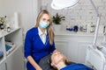 Young adult attractive professional beautician doctor portrait in protective face mask do facial care and treatment