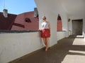 Young adult barefoot girl stands in the old corridor in the Castle Palanok Royalty Free Stock Photo