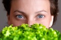 Young adult beautiful caucasian happy smiling woman portrait holding green fresh lettuce salad crop in front face Royalty Free Stock Photo