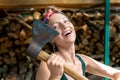 Young adult beautiful happy attractive caucasian brunette woman portrait have fun enjoy holding old rusty axe chopping firewood at Royalty Free Stock Photo
