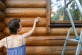 Young adult beautiful slim sporty caucasian woman stand near metal ladder and washing wooden house building wall Royalty Free Stock Photo