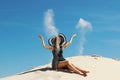 Young adult brunette woman relaxing on a beach. Happy Woman playing with sand at the beach. Pretty woman throwing sand up. Royalty Free Stock Photo