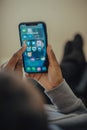 Young adult casually using a modern smartphone while relaxing on a comfortable sofa