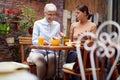 Young adult female talking to an elderly woman explaining something to her, while having breakfast together