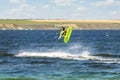 Young adult caucasian fit male person enjoy riding kite surf board making extreme trick stunt bright sunny day against