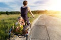 Young adult caucasian mom enjoy having leisure fun riding bicycle with cute adorable blond daughter holding wild field