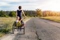 Young adult caucasian mom enjoy having leisure fun riding bicycle with cute adorable blond daughter holding wild field Royalty Free Stock Photo