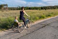 Young adult caucasian mom enjoy having leisure fun riding bicycle with cute adorable blond daughter holding wild field Royalty Free Stock Photo