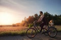 Young adult caucasian mom enjoy having leisure fun riding bicycle with cute adorable blond daughter holding wild field Royalty Free Stock Photo