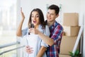 Young Adult Couple Inside Room with Boxes Holding New House Keys Royalty Free Stock Photo