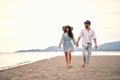 Young adult couple in love walking barefoot on beach, holding hands Royalty Free Stock Photo