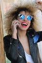 Young adult curly girl speaking at cellphone