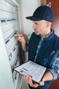 Young adult electrician in front fuse switch board