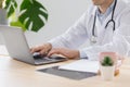 a young adult european and competent doctor in a white coat in a medical clinic in his office receives a patient Royalty Free Stock Photo