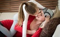 Young adult female cancer patient spending time with her daughter at home, relaxing on the couch. Cancer and family support. Royalty Free Stock Photo