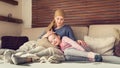 Young adult female cancer patient spending time with her daughter at home, relaxing. Cancer and family support concept. Royalty Free Stock Photo