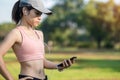 Young adult female listen music on smartphone during running in the park outdoor, runner woman jogging in the morning. Exercise, Royalty Free Stock Photo