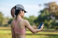 Young adult female listen music on smartphone during running in the park outdoor, runner woman jogging in the morning. Exercise, Royalty Free Stock Photo