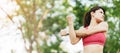 Young adult female in pink sportswear stretching muscle in the park outdoor, sport woman warm up ready for running and jogging in Royalty Free Stock Photo