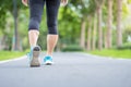 Young adult female in sport shoes running in the park outdoor, woman jogging and walking on the road at morning, leg muscles of Royalty Free Stock Photo