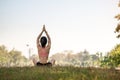 Young adult female in sportswear doing Yoga in the park outdoor, healthy woman sitting on grass and meditation with lotus pose in Royalty Free Stock Photo