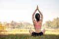 Young adult female in sportswear doing Yoga in the park outdoor, healthy woman sitting on grass and meditation with lotus pose in Royalty Free Stock Photo