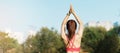 Young adult female in sportswear doing Yoga in the park outdoor, healthy woman sitting on grass and meditation with lotus pose in Royalty Free Stock Photo