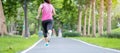 Young adult female in sportswear running in the park outdoor, runner woman jogging on the road, asian Athlete walking and exercise Royalty Free Stock Photo