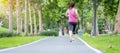 Young adult female in sportswear running in the park outdoor, runner woman jogging on the road, asian Athlete walking and exercise Royalty Free Stock Photo