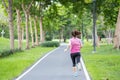 Young adult female in sportswear running in the park outdoor, runner woman jogging on the road, asian Athlete walking and exercise Royalty Free Stock Photo