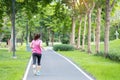 Young adult female in sportswear running in the park outdoor, runner woman jogging on the road, asian Athlete walking and exercise Royalty Free Stock Photo