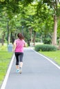 Young adult female in sportswear running in the park outdoor, runner woman jogging on the road, asian Athlete walking and exercise Royalty Free Stock Photo