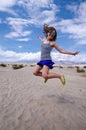 Young adult female woman jumps in the Mesquite Sand Dunes in Death Valley National Park in California Royalty Free Stock Photo