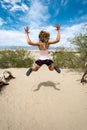 Young adult female woman jumps in the Mesquite Sand Dunes in Death Valley National Park in California Royalty Free Stock Photo