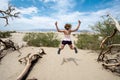 Young adult female woman jumps in the Mesquite Sand Dunes in Death Valley National Park in California Royalty Free Stock Photo