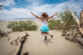 Young adult female woman jumps in the Mesquite Sand Dunes in Death Valley National Park in California Royalty Free Stock Photo