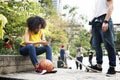 Young adult friends chilling at the park using smartphones and s